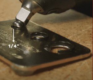 A piece of metal is being drilled with a screwdriver